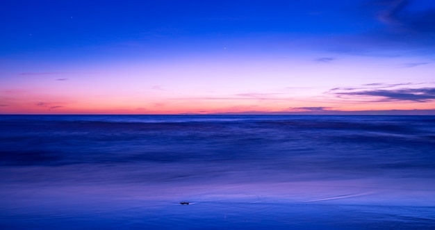 Beautiful motion blur long exposure sunset or sunrise with dramatic sky clouds over calm sea in tropical phuket island Amazing nature view and light of nature seascape.