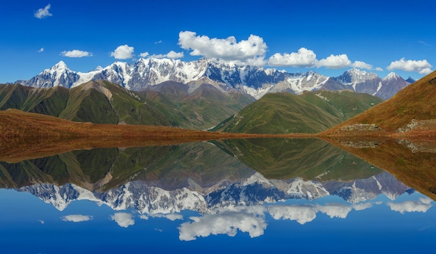 Beautiful mountain view of the snow-capped peaks reflected in a lake. Georgia. Svaneti