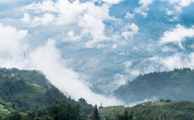 beautiful mountain with rice terraces and fog in morning near Sa Pa, Vietnam - popular tourist trekk