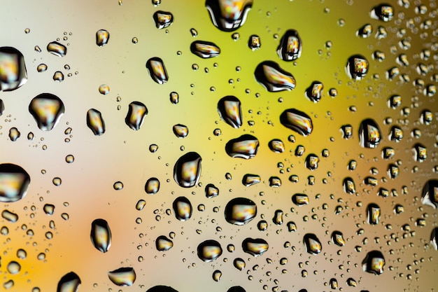 Beautiful multicolored water droplets on a glass