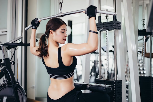 Beautiful muscular fit woman exercising building muscles and woman doing exercises 