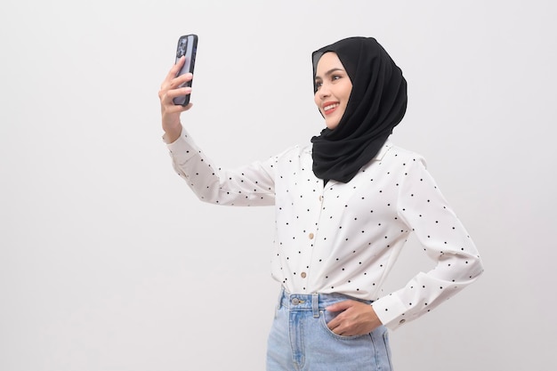 Beautiful musllim woman with hijab using smartphone over white background technology concept x9x9