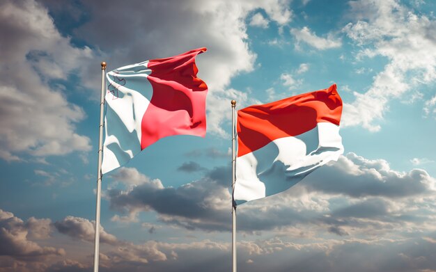 Beautiful national state flags of Malta and Indonesia together on blue sky