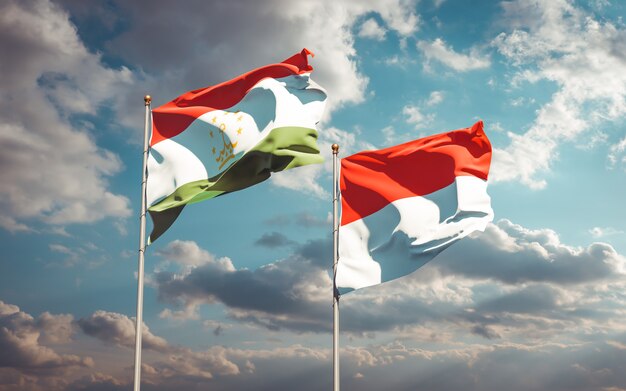 Beautiful national state flags of Tajikistan and Indonesia together on blue sky