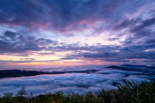 Beautiful nature landscape of the fog covers the summit and the colorful sky during sunrise in the winter, high angle view from the viewpoint of Phu Ruea National Park at Loei province, Thailand.