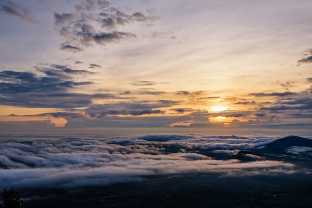 Beautiful nature landscape the sun is above the sea fog that covers the mountains and bright sky during sunrise in the winter at viewpoint of Phu Ruea National Park, Loei province, Thailand.