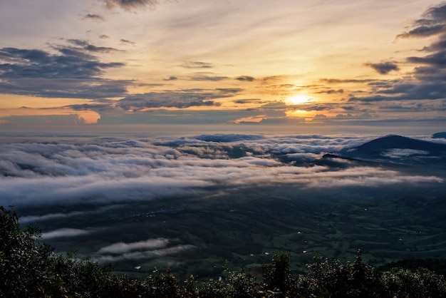 Beautiful nature landscape the sun is above the sea fog that covers the mountains and bright sky during sunrise in the winter at viewpoint of Phu Ruea National Park, Loei province, Thailand.