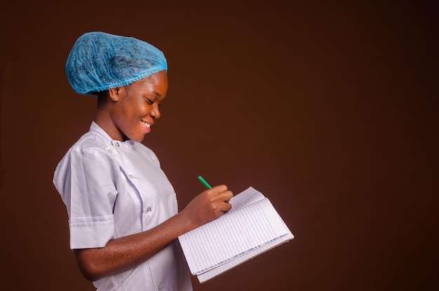 Beautiful nurse smiling and taking notes