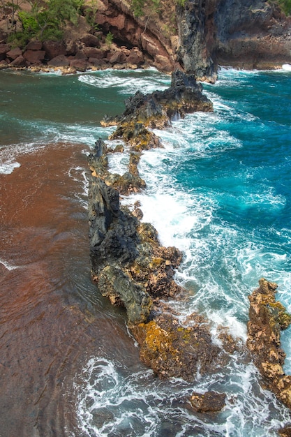 Beautiful ocean beach with large rocks on the shore and in the water waves in ocean summer holidays ...