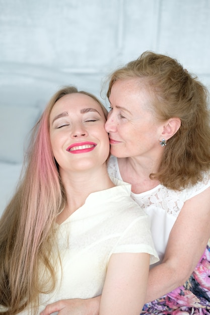 Beautiful old woman with her adult daughter in the bedroom. 