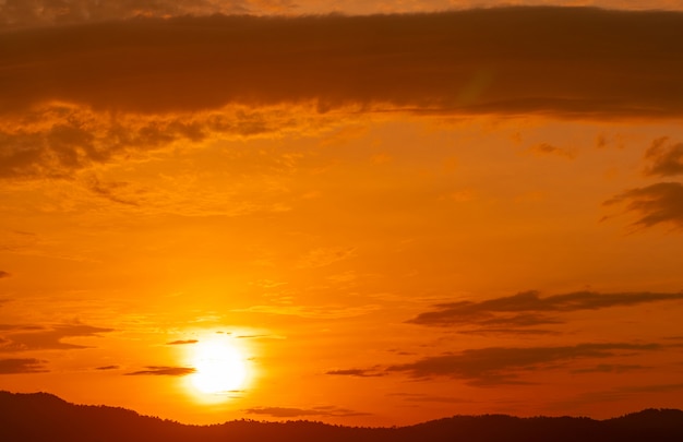 Beautiful orange sunset sky and clouds over the forest