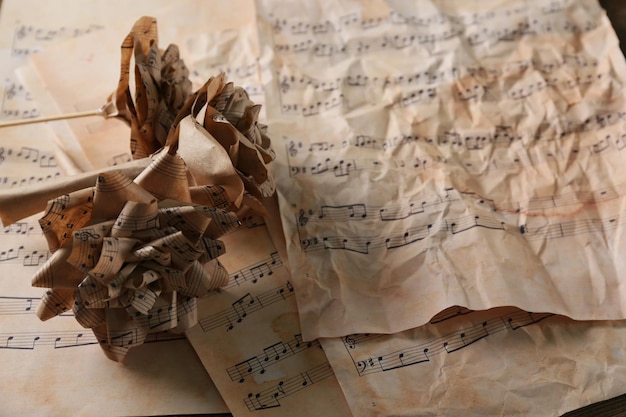 Beautiful paper-made roses on musical notes page background