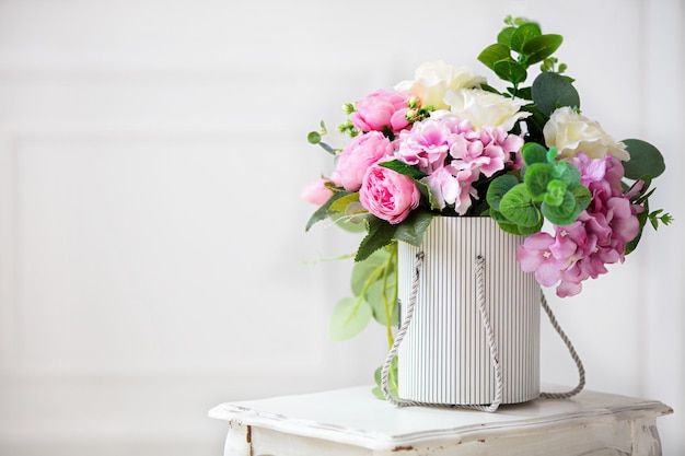 Beautiful peonies in a paper box on a white background