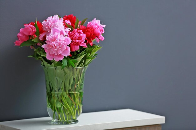 Beautiful peony bouquet on dark wall background