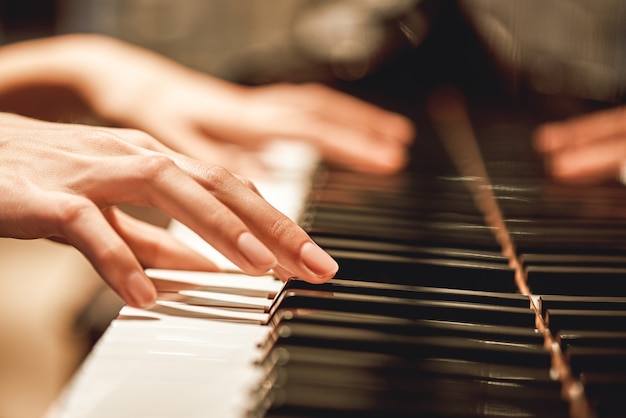 Beautiful piano melodyclose up view of female hands playing on piano her favorite classical music