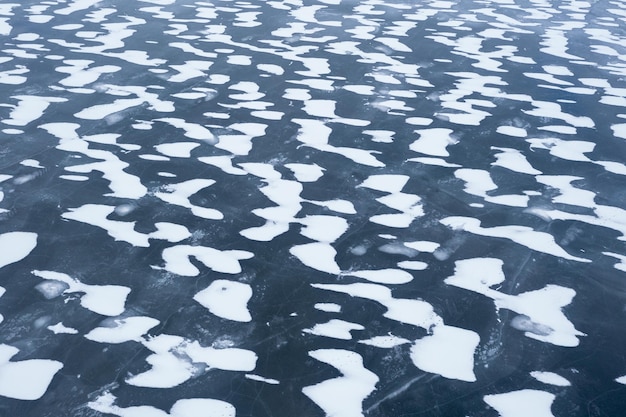 Beautiful piles of snow on ice frozen lake ice background winter background ice texture