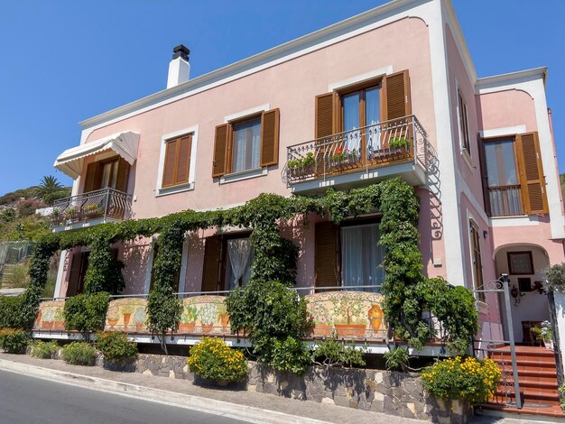 A beautiful pink colored house with balconies