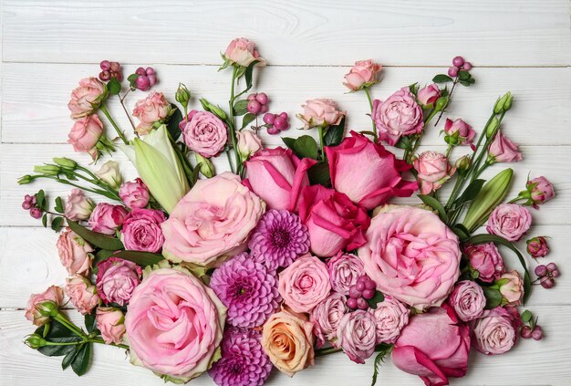 Photo beautiful pink flowers on white wooden table