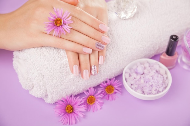 Beautiful pink and silver manicure with flowers and spa essentials