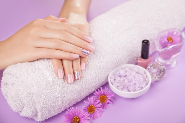 Beautiful pink and silver manicure with flowers and spa essentials