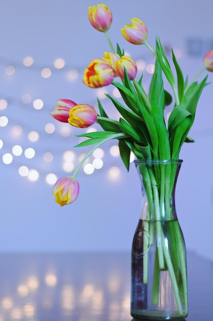 beautiful pink, yellow tulips on blue background with bokeh. Greeting card. 8 March. Holiday card