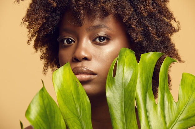 Beautiful portrait of African American woman against a background of green exotic plants