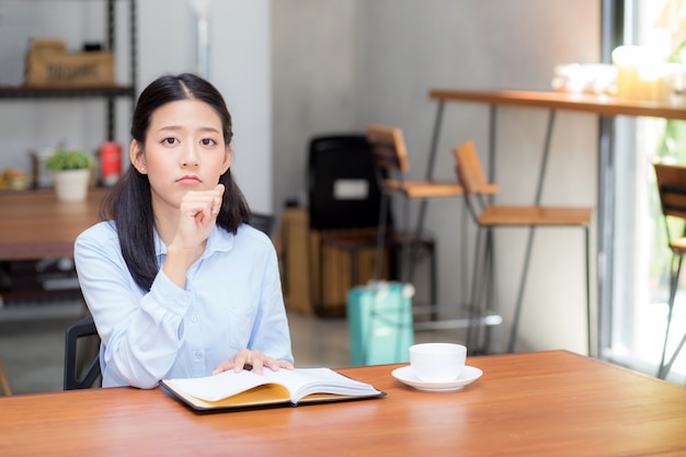 Beautiful of portrait business asian woman thinking idea and writing on notebook