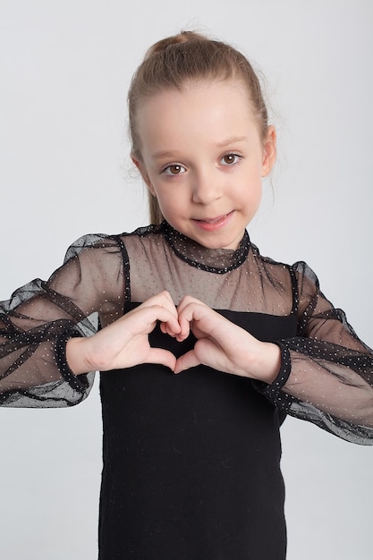 Beautiful portrait of a happy smiling cute girl in the studio on a white background children's emotions