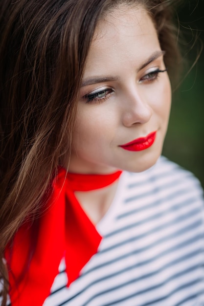 A beautiful portrait of a woman with bright red lipstick and a scarf around