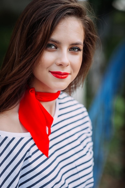 A beautiful portrait of a woman with bright red lipstick and a scarf around