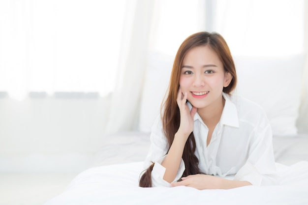 Beautiful portrait young asian woman lying and smile while wake up.