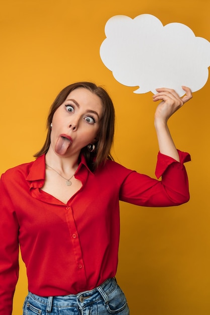 A beautiful positive young Caucasian woman is holding an empty banner on a yellow background Copying space Sale Positive emotions