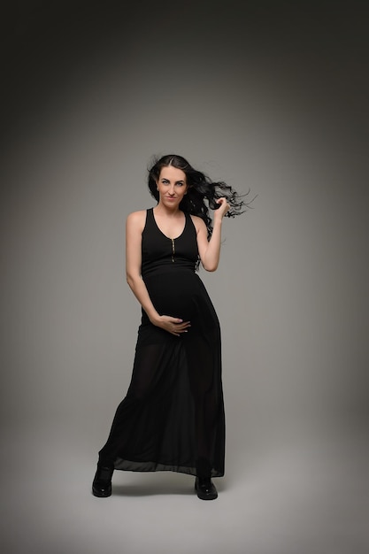 Beautiful pregnant girl on a gray background Mother's Day