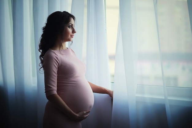 Beautiful pregnant girl with a big belly. Young married pregnant couple. Husband with a pregnant wife. A couple awaiting the birth of a baby.