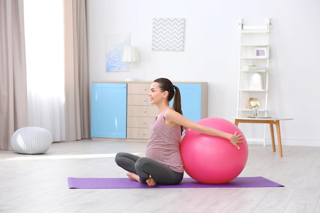 Beautiful pregnant woman doing exercise at home