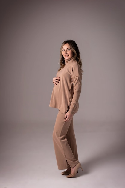 Beautiful pregnant woman on a gray background Mother's Day