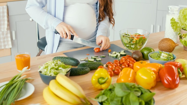 Beautiful Pregnant Woman Happily Preparing a Vegetable Salad The Concept Of Diet