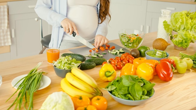 Beautiful Pregnant Woman Happily Preparing a Vegetable Salad The Concept Of Diet