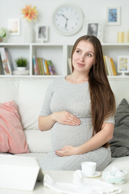 Beautiful pregnant woman posing on sofa