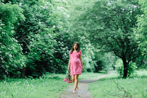 Beautiful pregnant woman relaxing outside in the park