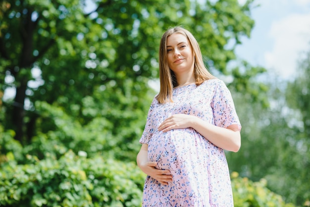 Beautiful pregnant woman relaxing in the park