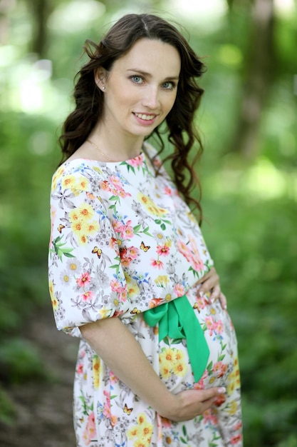 Beautiful pregnant woman in a sunset outside in the park