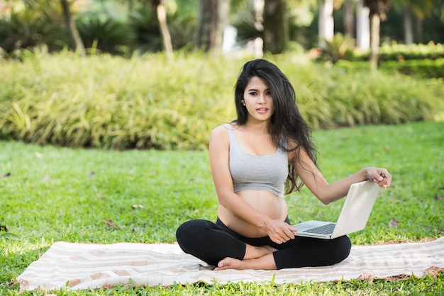 Beautiful pregnant woman yoga in the park