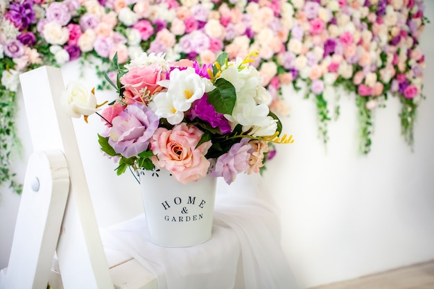 Beautiful Provence-style interior with a bright floral wall, bucket with artificial flowers