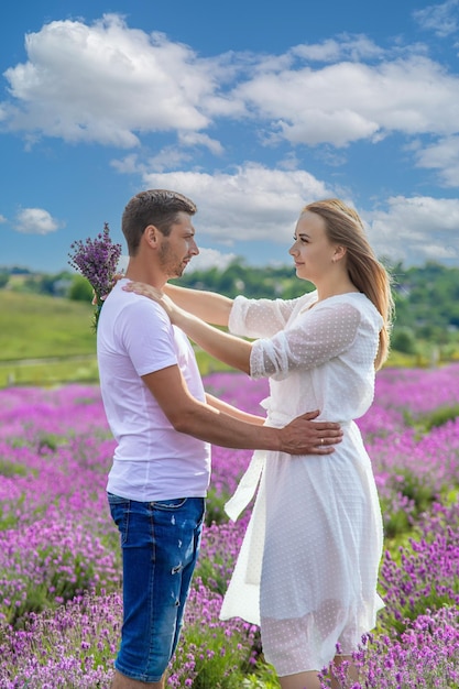 Beautiful purple lavender flowers in a summer field couple holding hands