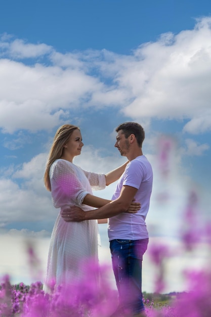 Beautiful purple lavender flowers in a summer field couple holding hands