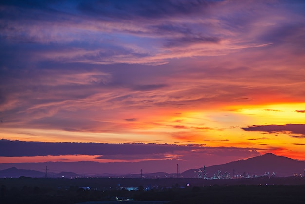 Beautiful radiant sun lighting in twilight. Colorful brightly soft and fluffy clouds on purple sky after hard raining.