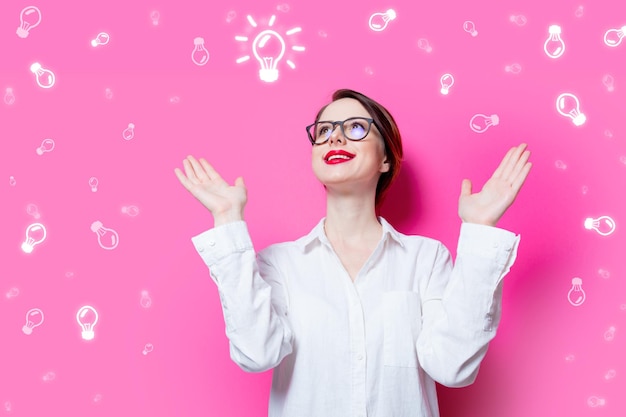 Beautiful red-haired businesswoman on pink background