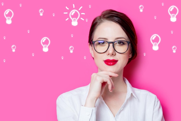 Beautiful red-haired businesswoman on pink background