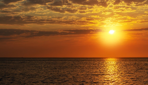 Beautiful red sunset, dark clouds and ocean on the horizon